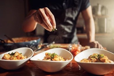 Chef tossing pasta at a live counter