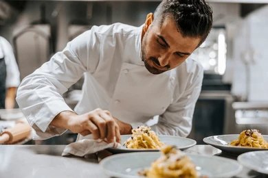 Chef plating food in a clean kitchen